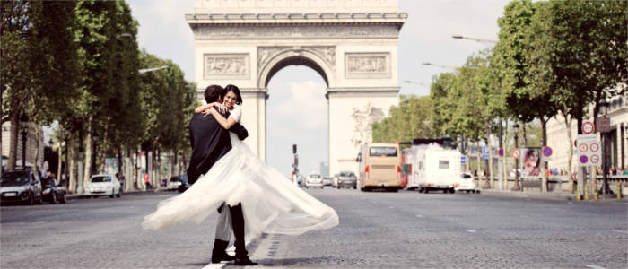 Young newly-weds in front of the Arc de Triomphe